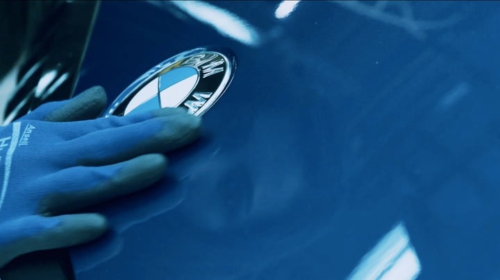 A gloved hand on a BMW badge