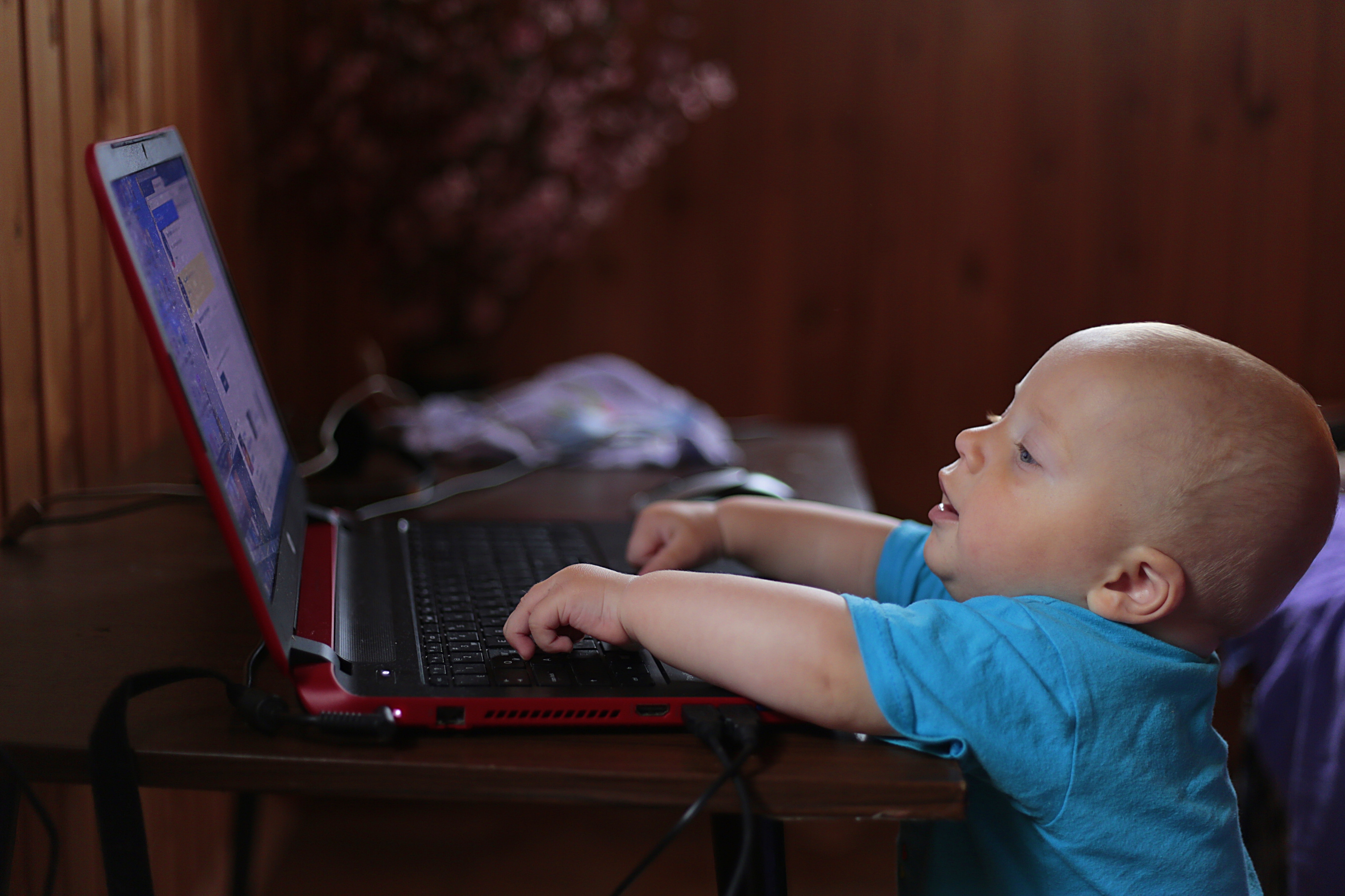 boy-wearing-blue-t-shirt-using-black-laptop-computer-in-a-159533