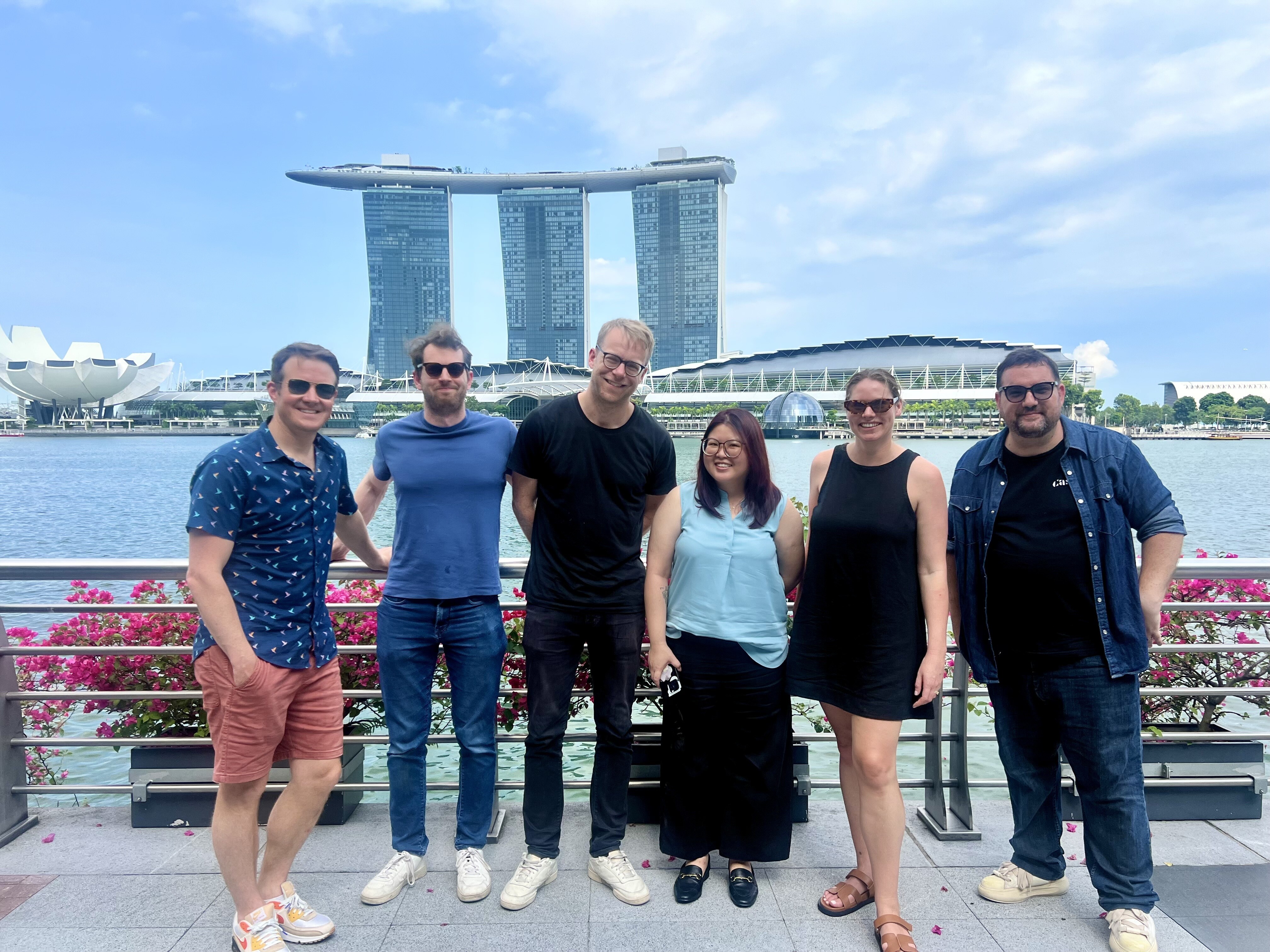 A group of people standing in front of the Singapore skyline
